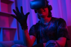 metaverse-technology-concept-man-wear-vr-goggles-glove-making-gesture-while-playing-games-1-scaled